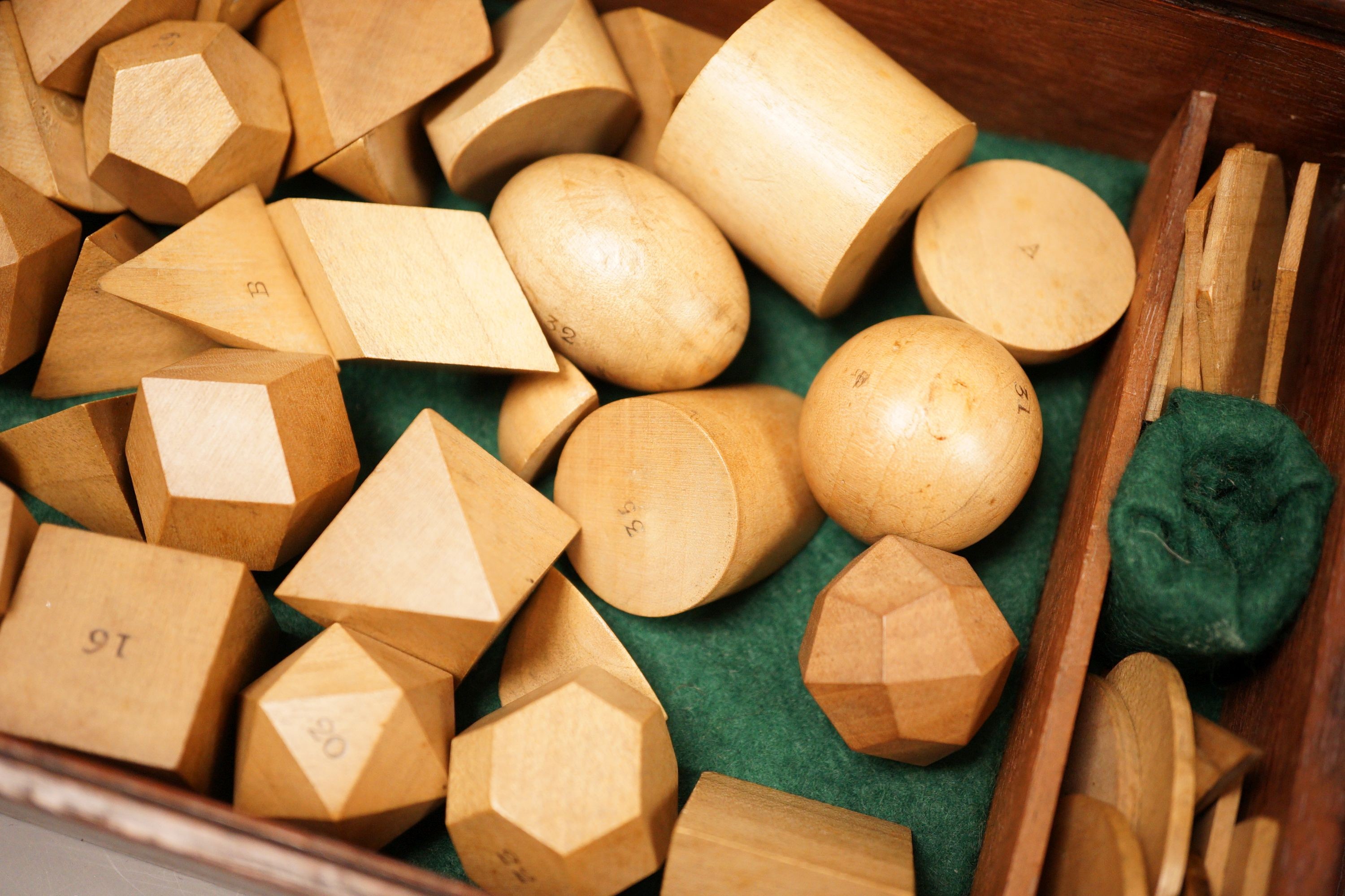 A mahogany cased set, Edwards Geometrical Planes and Solids': 19th century educational carved wooden geometry instructional set, with paper label to cover